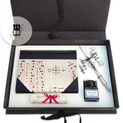 Diario in pelle nera e carta con motivo "musica antica", penna con pennino a chiave di violino, inchiostro.